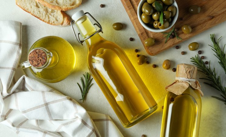 Concept of tasty eating with olive oil on white textured background