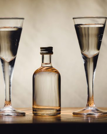different alcohol bottles are on the table on a light background.